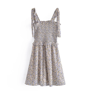Robe d'été vintage à fleurs avec buste froncé et bretelles à nouer sur fond blanc