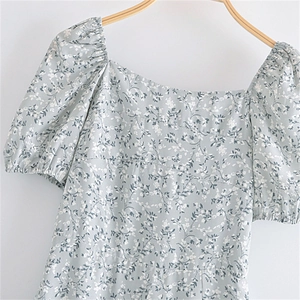 Detail of light blue floral dress with square neckline and puff sleeves on hanger