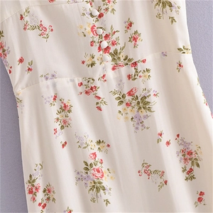 Détail de la robe fleurie crème avec boutons blancs et coupe ajustée à la taille