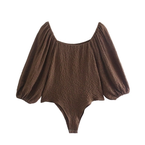 Detail view of brown textured bodysuit with puff long sleeves and square neckline