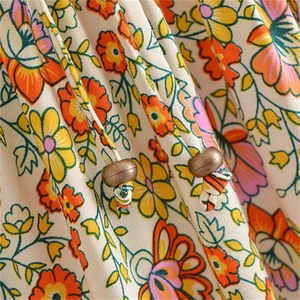 Détail macro du tissu floral en coton avec cordon et anneau en métal bronze brossé