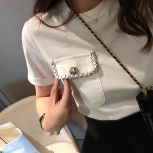 Detail of elegant white T-shirt with tweed trim pocket and vintage metal button accent