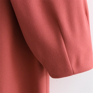 Detail of pink wool coat showing soft fabric texture and sleeve cuff craftsmanship