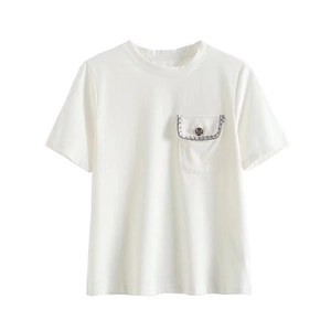 Close-up of white t-shirt pocket with silver chain and metal button detail