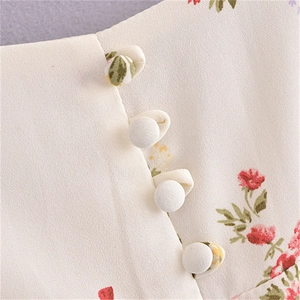 Vue macro détaillée des boutons recouverts de tissu sur une robe vintage à fleurs