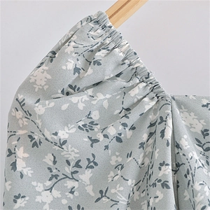 Detail of square neckline and puff sleeves on a floral print dress with smocked elastic