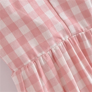 Détail du tissu vichy rose et blanc avec texture plissée et travail de couture fine