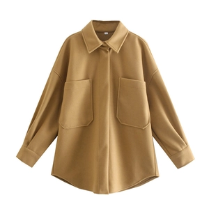 Close-up of oversized camel wool shacket featuring large front pockets and collar detail
