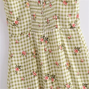 Dettaglio del tessuto vichy verde con stampa floreale e texture elasticizzata