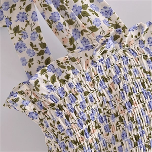 Détail de la robe à fleurs avec buste élastique smocké et bordure à volants délicats