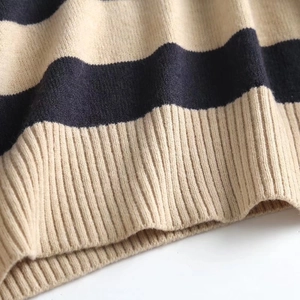 Detailed macro view of thick knit fabric with beige and navy blue stripes and ribbed hem