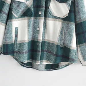 Green and white plaid flannel shacket featuring metallic buttons and curved hem line