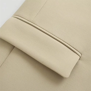 Front detail of beige oversized blazer showing flap pocket and premium woven texture