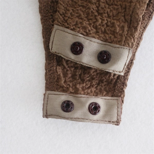 Detail of snap button closure and textured bubble fabric on slim fit brown bodysuit