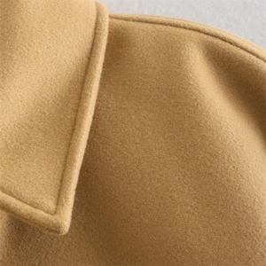 Macro shot of khaki wool fabric texture showing fine stitching and warm material details