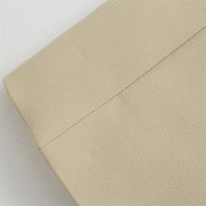 Macro shot of the beige textured canvas fabric showing durable stitched seams and corners