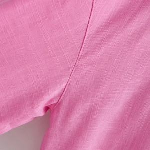Nahaufnahme der rosa Baumwolltextur und gleichmäßigen Nähte am Saum des Hemdes