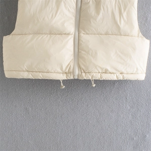 Close-up of cream quilted vest featuring a zipper closure and adjustable drawstring hem