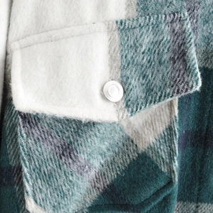 Close-up of brushed plaid wool jacket with silver metal snap and chest pocket detail