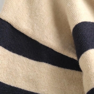 Macro detail of soft knit fabric with cream and navy stripes on this casual cardigan