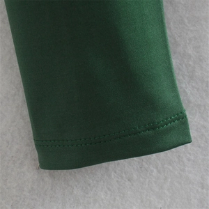 Gros plan sur un tricot vert foncé montrant les détails de finition de la double couture
