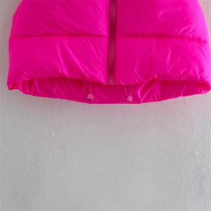 Detail of rose pink puffer vest featuring a full zipper and adjustable hem drawstrings