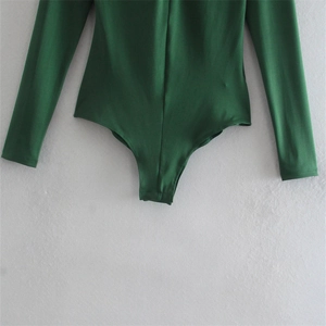 Détail de l'échancrure haute et du tissu extensible de ce body vert foncé à manches longues