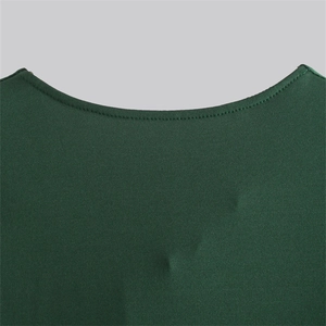 Détail de l'encolure en V vert foncé montrant les coutures précises et la texture du tissu