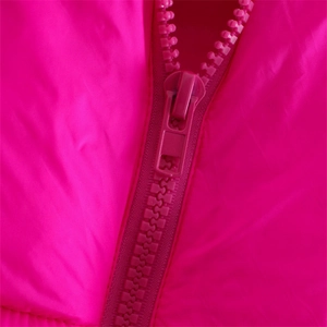 Close-up of vibrant pink puffer vest featuring a high-quality zipper and stand collar