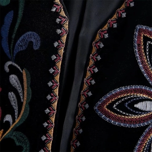 Primer plano del bordado floral de colores en la tela de terciopelo negro de la chaqueta
