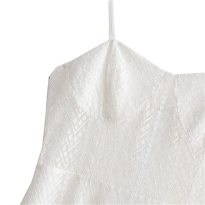 Détail du tissu en dentelle blanche avec jacquard floral et fines bretelles délicates