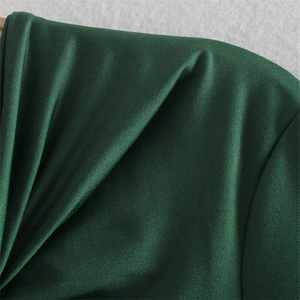 Détail macro du tissu côtelé vert foncé avec un subtil éclat satiné et texture fine