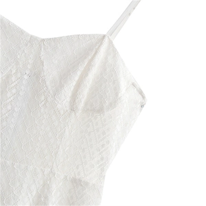 Détail d'un caraco en dentelle blanche montrant un motif en maille et fines bretelles