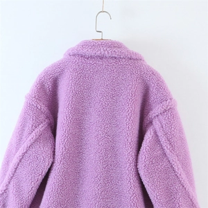 Detail view of purple teddy fleece coat showing thick textured faux fur and lapel collar
