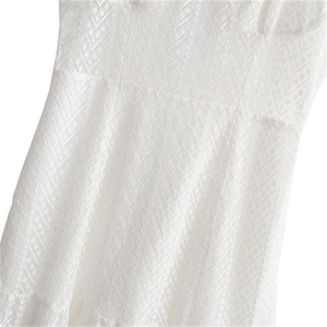 Robe élégante en dentelle blanche avec broderie ajourée et détails de texture géométrique