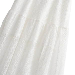 Gros plan sur le tissu en dentelle blanche avec motif géométrique ajouré d'une robe
