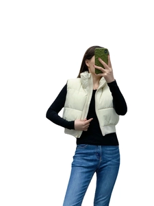 Détail d'un gilet matelassé beige à col montant avec fermeture éclair pour femmes