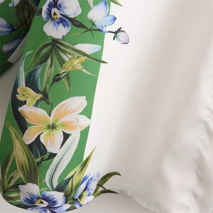 Close-up of floral print shirt fabric with white and green contrast stitching detail
