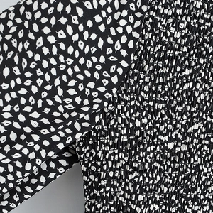 Detail of smocked elastic waist featuring black and white abstract leaf print fabric