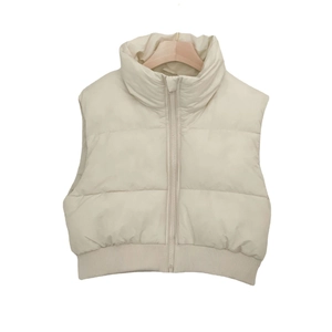 Détail du gilet matelassé beige avec col montant, fermeture éclair et ourlet élastique