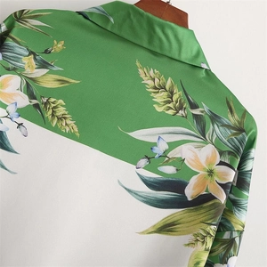 Detail of satin shirt with tropical floral lily print and green diagonal contrast