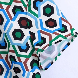 Détail de la manche courte d'une robe avec imprimé géométrique bleu et vert rétro