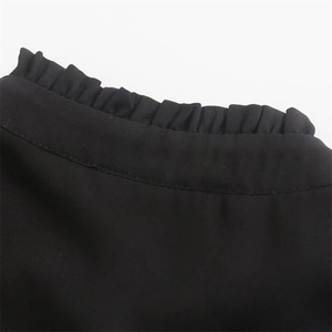 Dettaglio della camicia nera con colletto alla coreana arricciato e texture opaca premium