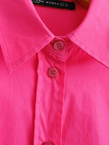 Macro detail of high-quality stitching on bright pink poplin shirt collar and buttons