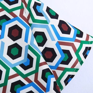 Détail du tissu à imprimé géométrique hexagonal en bleu, vert et marron