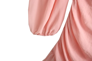 Detailed view of pink chiffon dress featuring pleated fabric and elasticated cuffs