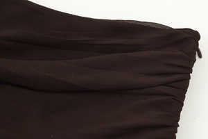Detailed macro view of dark brown pleated fabric with high-quality invisible zipper closure