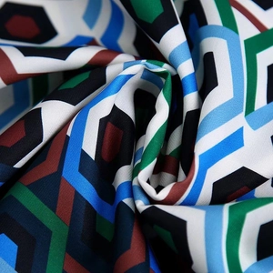 Gros plan d'un tissu à motifs géométriques montrant la texture soyeuse et le détail du drapé