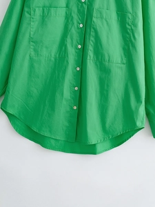 Close-up of bright green poplin shirt featuring white buttons and large chest pockets