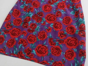 Vue détaillée de l'imprimé floral vintage sur tissu violet avec roses rouges et feuilles